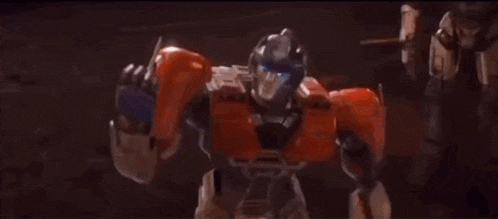 a close up of a transformer robot with blue eyes and red arms .