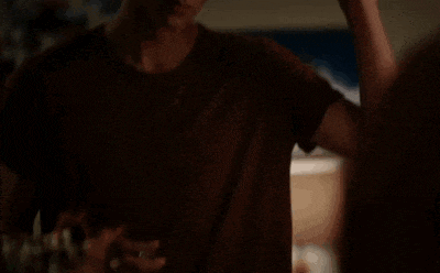 a young man is spraying perfume on his face