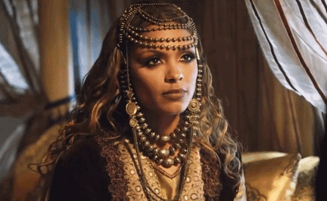 a woman wearing a necklace and a headdress with beads