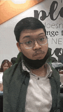 a man wearing glasses and a mask looks at the camera