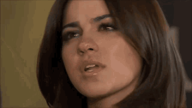 a close up of a woman 's face with a serious expression
