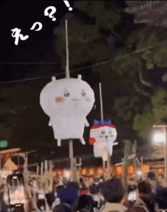 a couple of stuffed animals are hanging from a rope in a crowd of people .