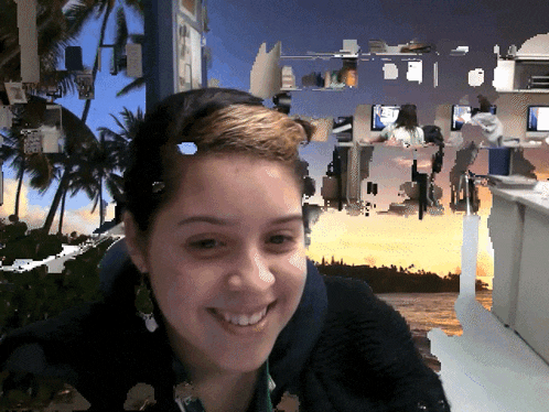 a woman is smiling in front of a blurry picture