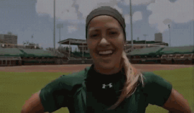 a woman wearing a green under armour shirt smiles