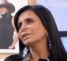 a close up of a woman 's face with a picture of a man in the background .