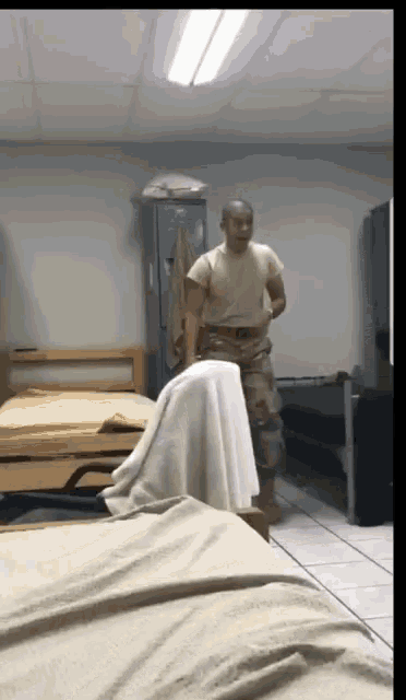 a man in a military uniform is standing in a room filled with beds