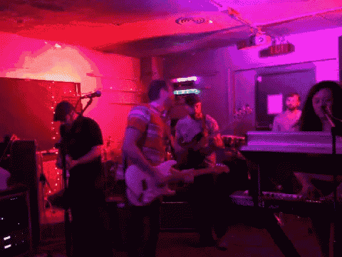 a group of people playing instruments in front of a sign that says " exit "
