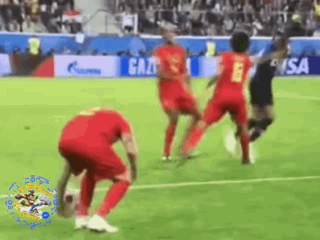 a group of soccer players are playing on a field with visa in the background