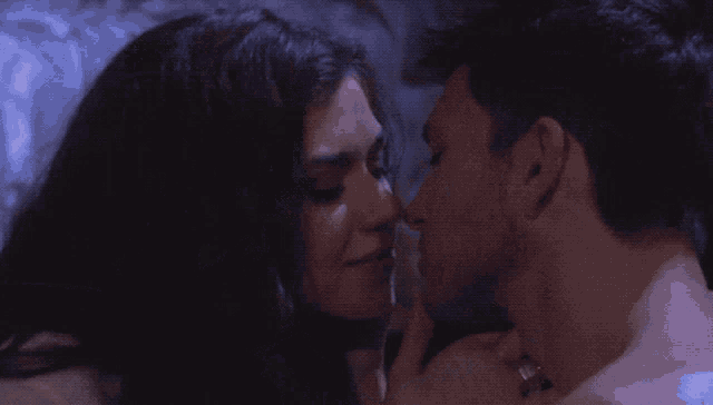 a man and a woman are kissing on a bed