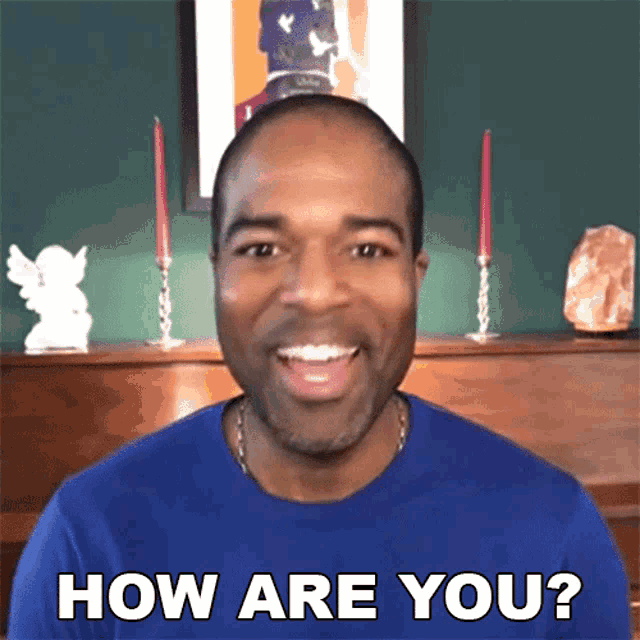 a man in a blue shirt is smiling and says how are you