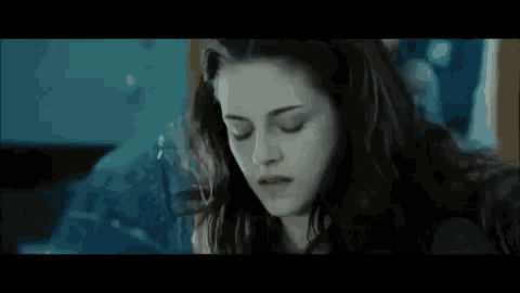 a close up of a woman 's face with her eyes closed and her hair blowing in the wind .