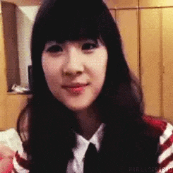 a young woman with long black hair and a striped shirt and tie is smiling .