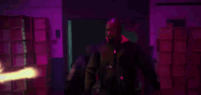 a bunch of boxes are stacked on top of each other in a room with purple lights behind them .
