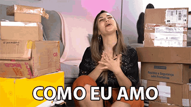 a woman sitting in front of a pile of boxes with the words como eu amo