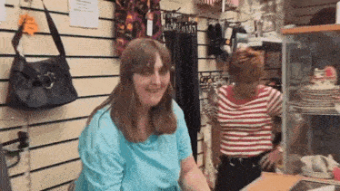 two women are standing in a store talking to each other .