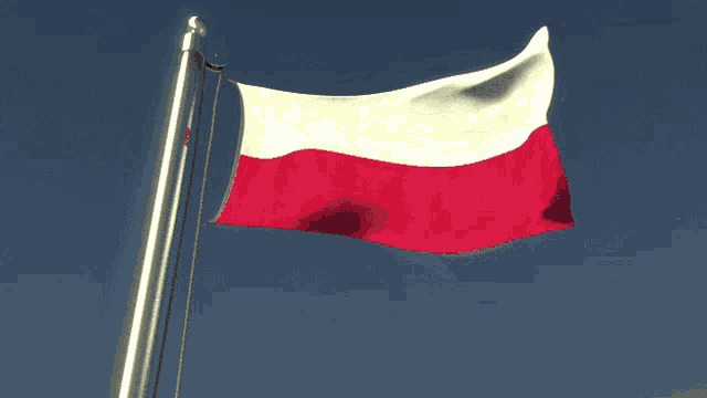 a red and white flag waving in the wind