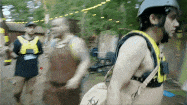 a shirtless man wearing a helmet and carrying a bag with a skull on it