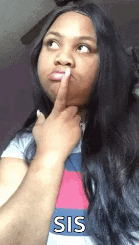 a woman with long black hair is making a funny face while holding her finger to her mouth .