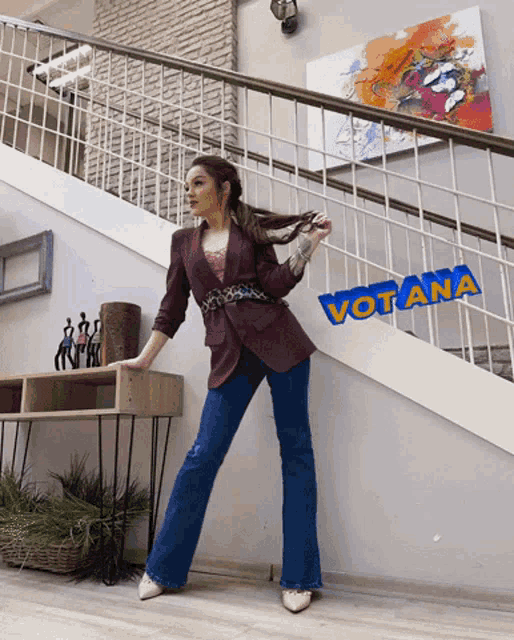 a woman standing on a set of stairs with the word votana on the wall