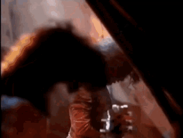 a person is playing a guitar in a dark room with a fire in the background .