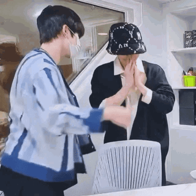 two men are giving each other a high five in an office .