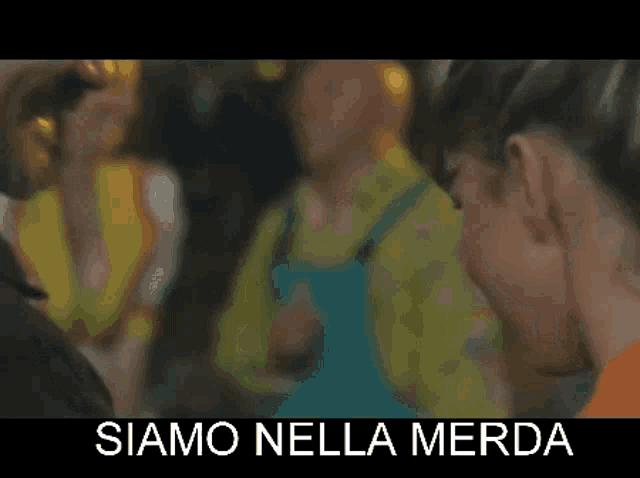 a blurry picture of people with the words siamo nella merda on the bottom