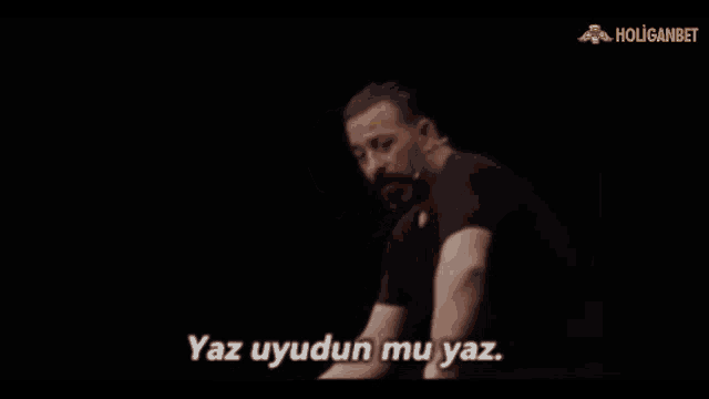 a man in a black shirt with the words yaz uyudun mu yaz on the bottom