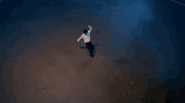 a man in a white shirt is standing in a spotlight