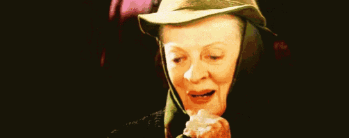 a close up of a woman wearing a hat and holding a piece of paper in her hand .