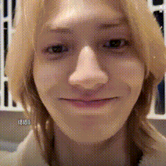 a close up of a woman 's face with long blonde hair and a smile on her face .
