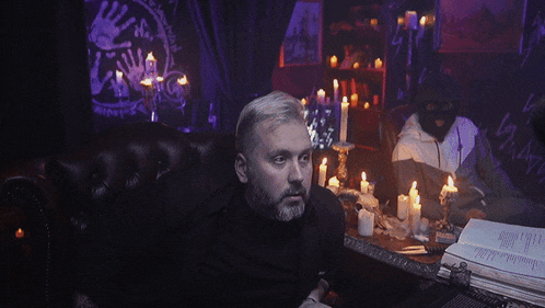 a man sitting at a table with candles says party