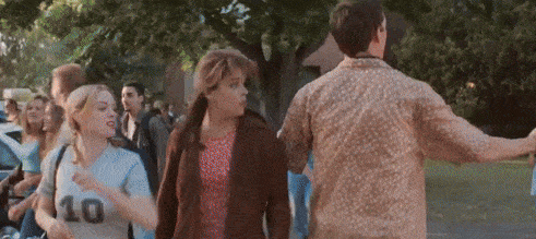 a group of people are walking down a street and one of them has the number 10 on her shirt