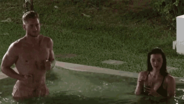 a man and a woman are standing in a pool of water