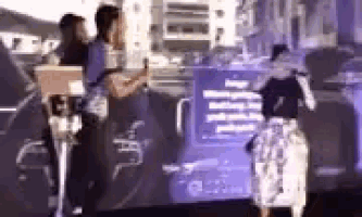 a group of people are standing in front of a purple screen .