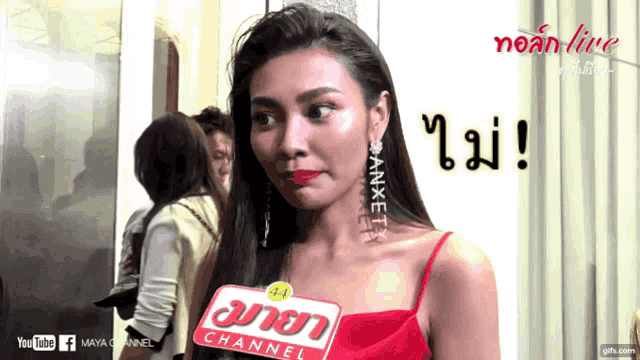 a woman in a red dress is talking into a microphone with maya channel written on it