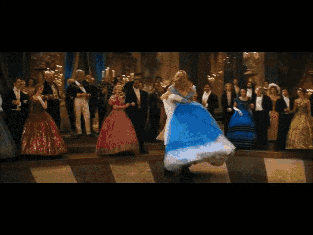 a woman in a blue dress dancing in front of a crowd
