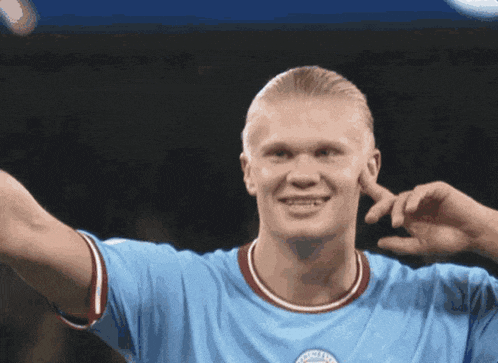 a soccer player wearing a light blue jersey with the city logo on it