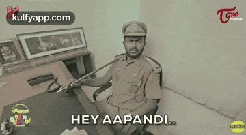 a man in a police uniform is sitting at a desk with a microphone and says hey aapandi .