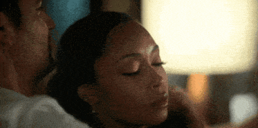 a close up of a woman 's face with a man 's arm around her neck