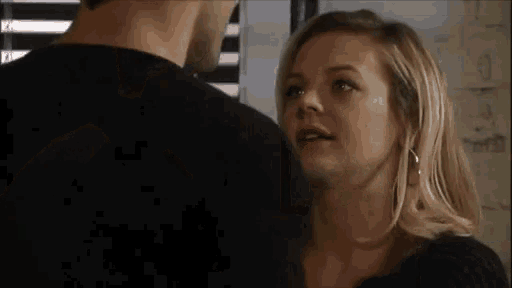 a man and a woman are looking at each other .