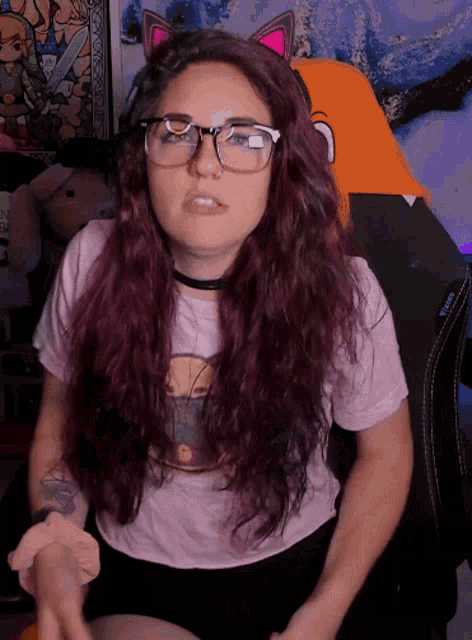 a woman wearing glasses and a pink shirt with a picture of a person on it