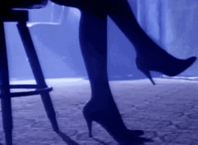 a woman wearing high heels is sitting on a bar stool .