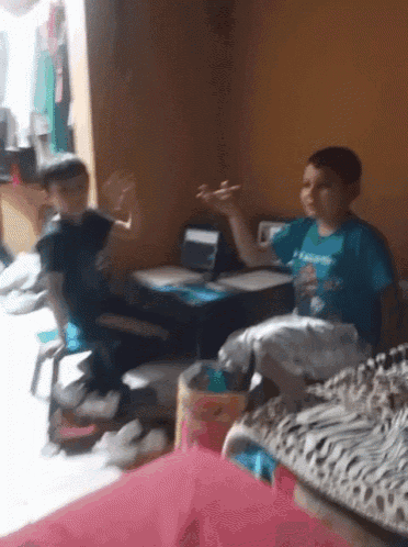 a boy wearing a blue shirt that says i love you is sitting in a room