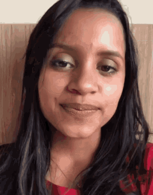 a close up of a woman 's face with a wooden background