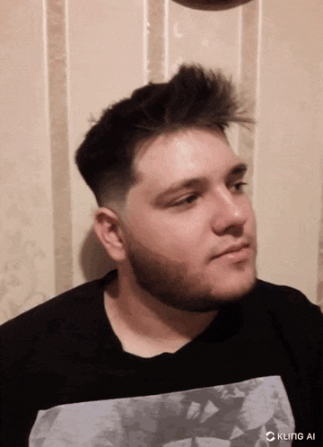 a man with a beard is wearing a black shirt with a white graphic on it