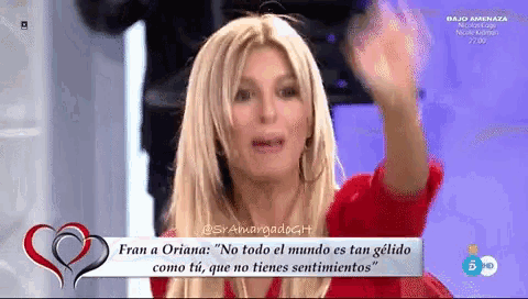 a woman in a red shirt is talking on a television screen