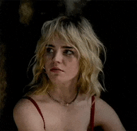 a woman with blonde hair and a necklace is wearing a red tank top and a necklace .