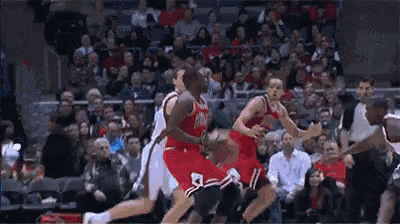a group of basketball players are playing a game on a court in front of a crowd .