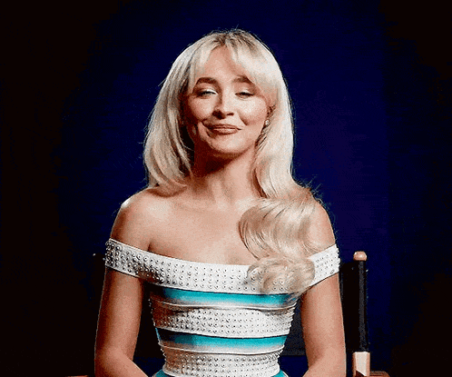 a woman in a striped dress is sitting in a chair with her eyes closed and smiling .