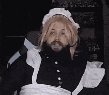 a man with a beard is dressed in a maid costume .